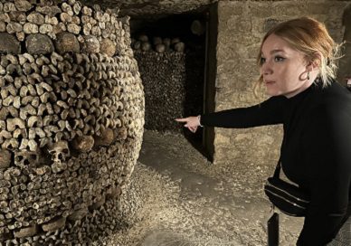 girl pointing to barrel of catacombs bones